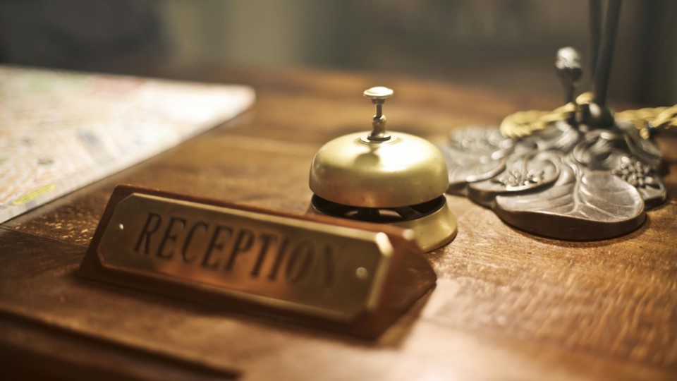 A sign that says reception at the front desk of a hotel lobby
